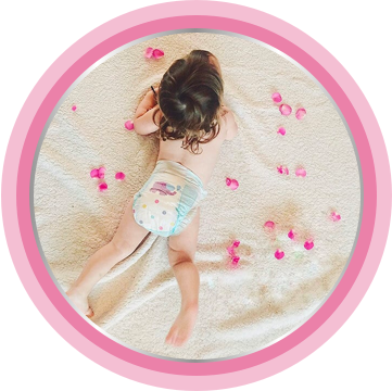 Serba Serbi Keluhan Kulit pada Bayi Area Popok | Bepanthen - Bayi baru lahir berbaring di tempat tidur dengan kelopak mawar selembut krim pelembab kulit bayi Bepanthen